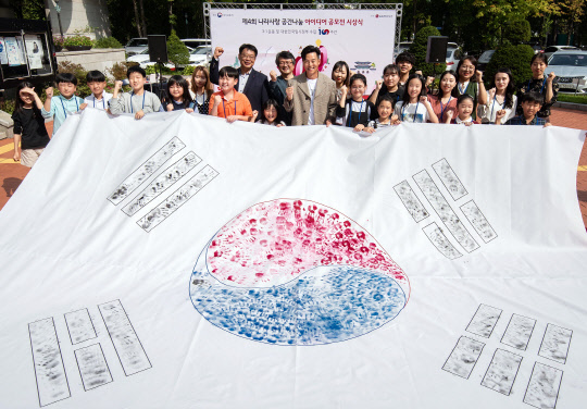 LG하우시스와 국가보훈처는 지난 4일 서울 서초구 양재동에 있는 매헌윤봉길의사기념관에서 ‘제4회 나라사랑 공간나눔 아이디어 공모전’ 시상식을 개최했다고 6일 밝혔다. 사진은 시상식 행사 참석자들과 LG하우시스 모델로 활동 중인 배우 이서진씨가 직접제작한 손도장 태극기를 들고 기념촬영을 하는 모습.  <LG하우시스 제공>